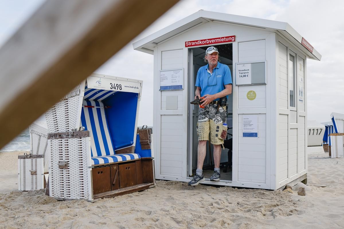 Strandkorbwärter Mathias Tognino tritt zu Dienstbeginn aus seiner Vermietungsstation am Strand von Westerland auf Sylt. 