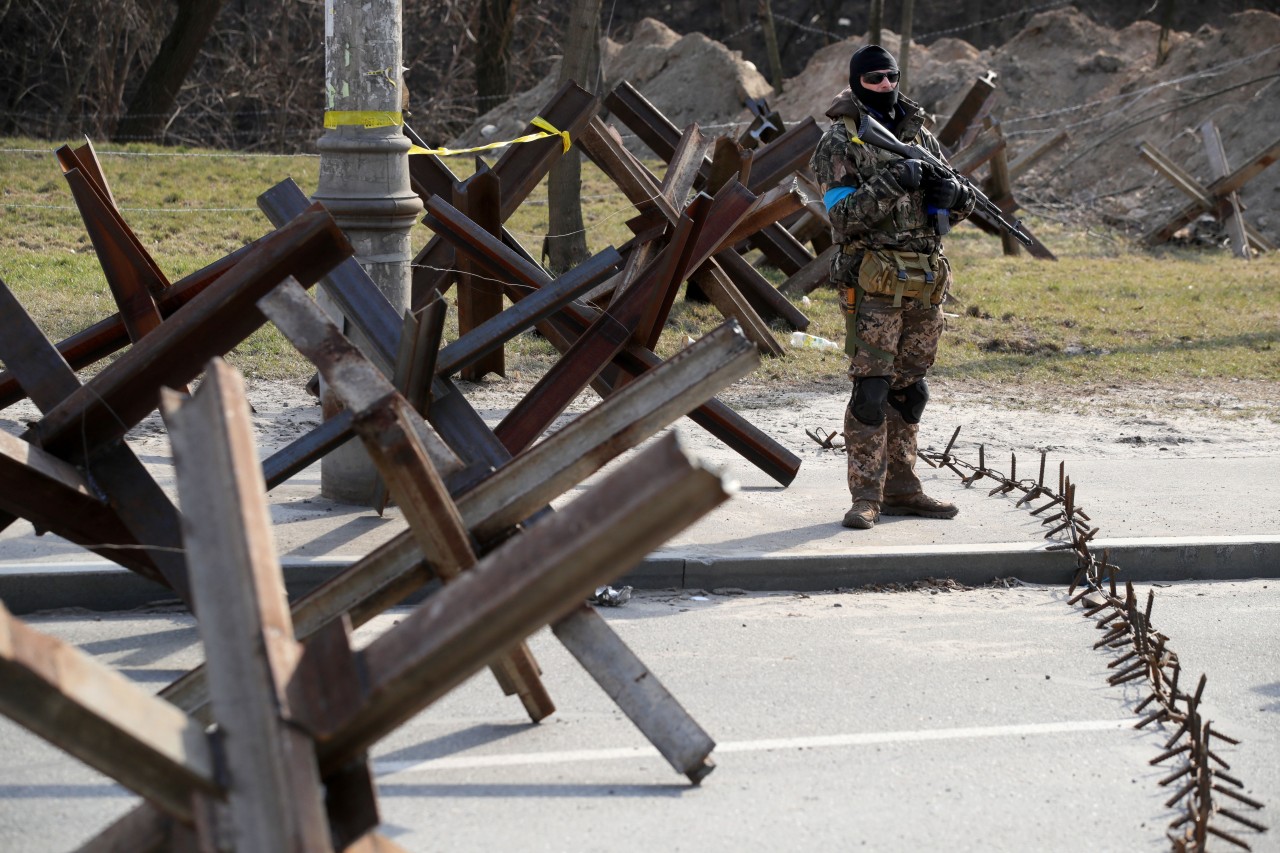 Ein ukrainischer Soldat an einer Barrikade mit Panzersperren (Symbolfoto).