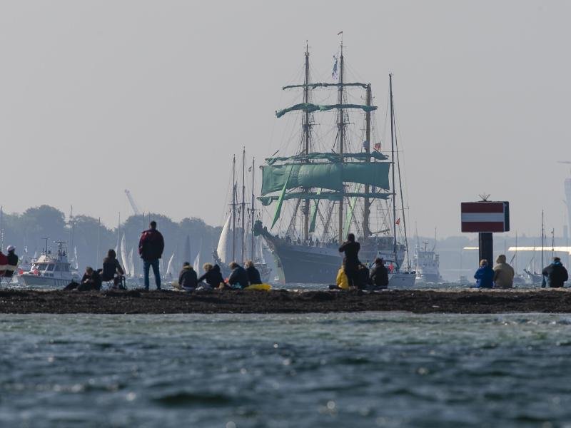 Zuschauer beobachten am Falkensteiner Strand die Windjammer-Parade der Kieler Woche. Die Stadt rechnet zum Sommerfest vom 18. bis 26. Juni mit einem Millionen-Publikum.