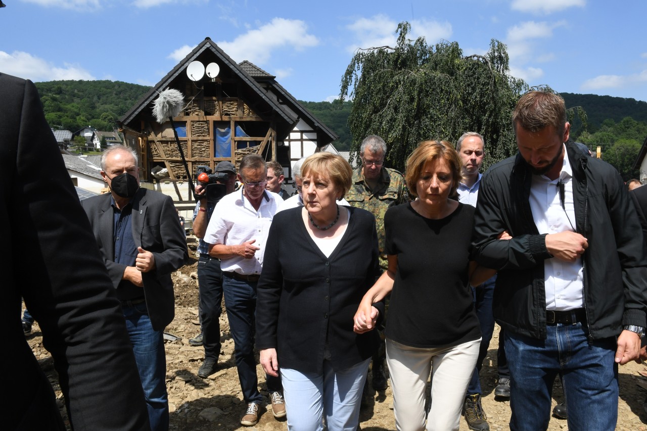 Bundeskanzlerin Angela Merkel (3.v.r.) und Malu Dreyer (2.v.r,SPD), Ministerpräsidentin von Rheinland-Pfalz, gehen durch das vom Hochwasser verwüstete Dorf Schuld