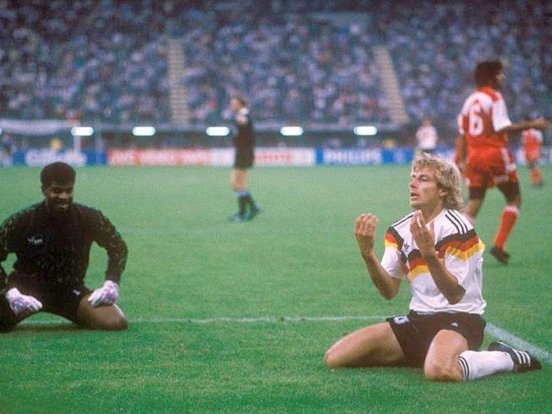 Das Bild zeigt Jürgen Klinsmann, der verzweifelt am Boden kniet, daneben Torwart Mushin Musabeh Faraj (Vereinigte Arabische Emirate).