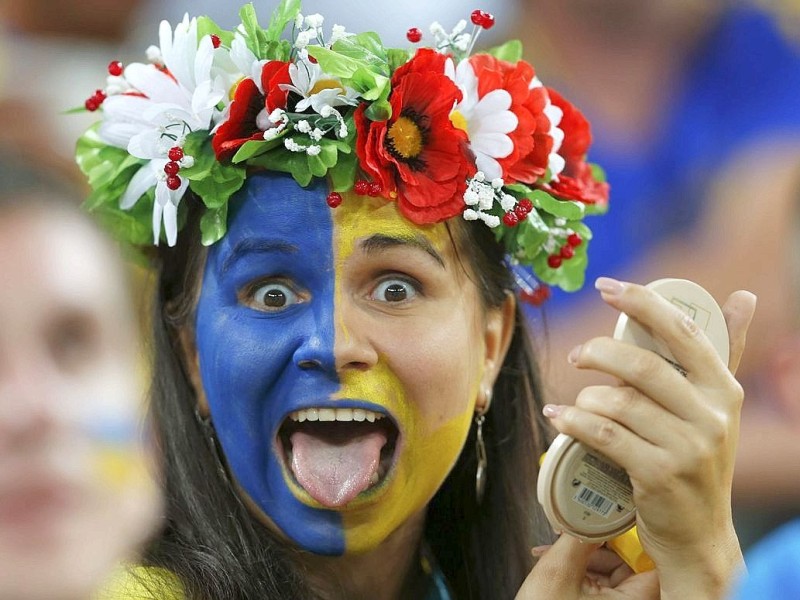 ... sich wie dieser weibliche Ukraine-Fan mit Hingabe verkleidet und ...