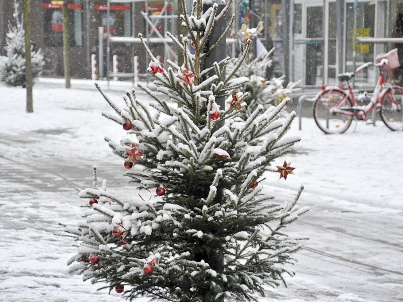 In der Fußgängerzone in Duisburg steht dieser verschneite Weihnachtsbaum.