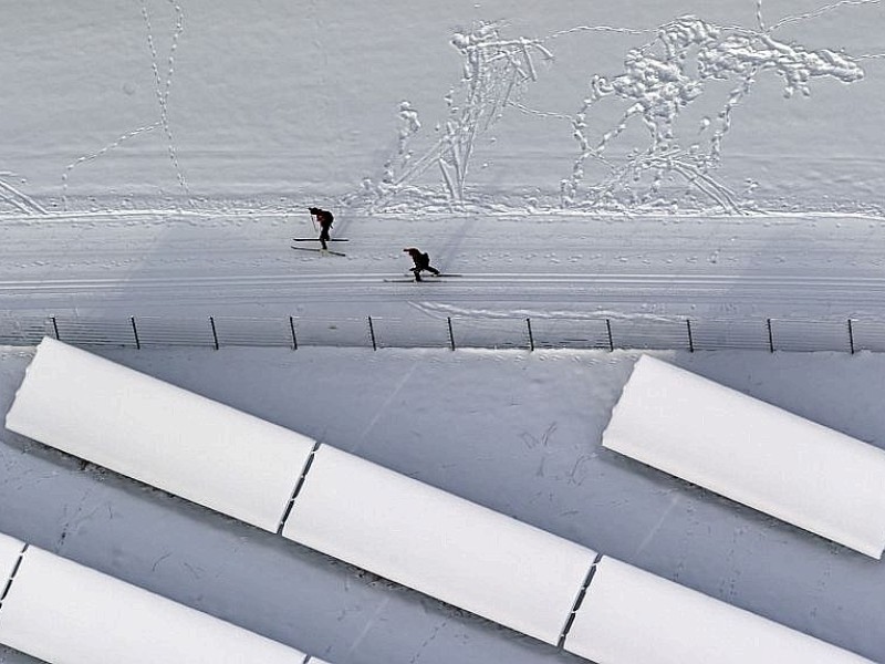 Skilangläufer neben einer zugeschneiten Solaranlage.