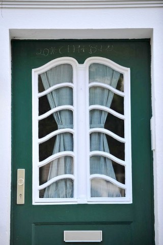 Jedes Gebäudeensemble hat individuelle verstrebte Fenster in der stets grünen Haustür - eine Auswahl.
