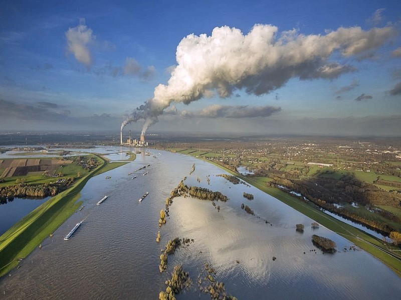 Die Wolken aus Wasserdampf spiegeln sich im Wasser des Rheins.