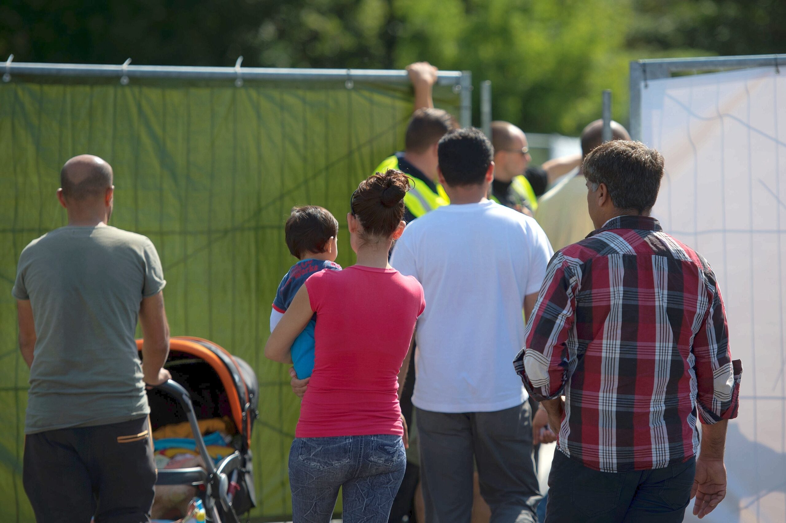 Kurz vor dem Besuch der Bundeskanzlerin gehen Flüchtlinge zur Unterkunft.
