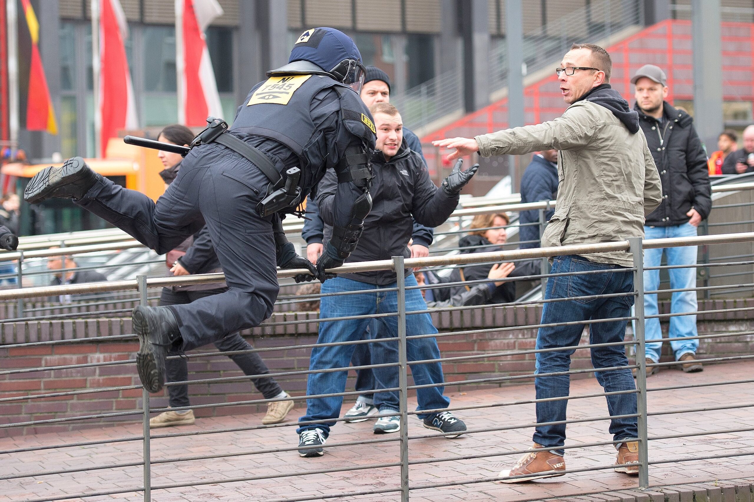 Ein Polizist springt am 25.10.2015 in Köln (Nordrhein-Westfalen) über ein Geländer. Die Gruppierung Hooligans gegen Salafisten (Hogesa) demonstriert in Köln, während mehrere Gegendemos und Veranstaltungen angemeldet sind. Die Polizei rechnet mit bis zu 23.000 Teilnehmern insgesamt. Foto: Marius Becker/dpa +++(c) dpa - Bildfunk+++