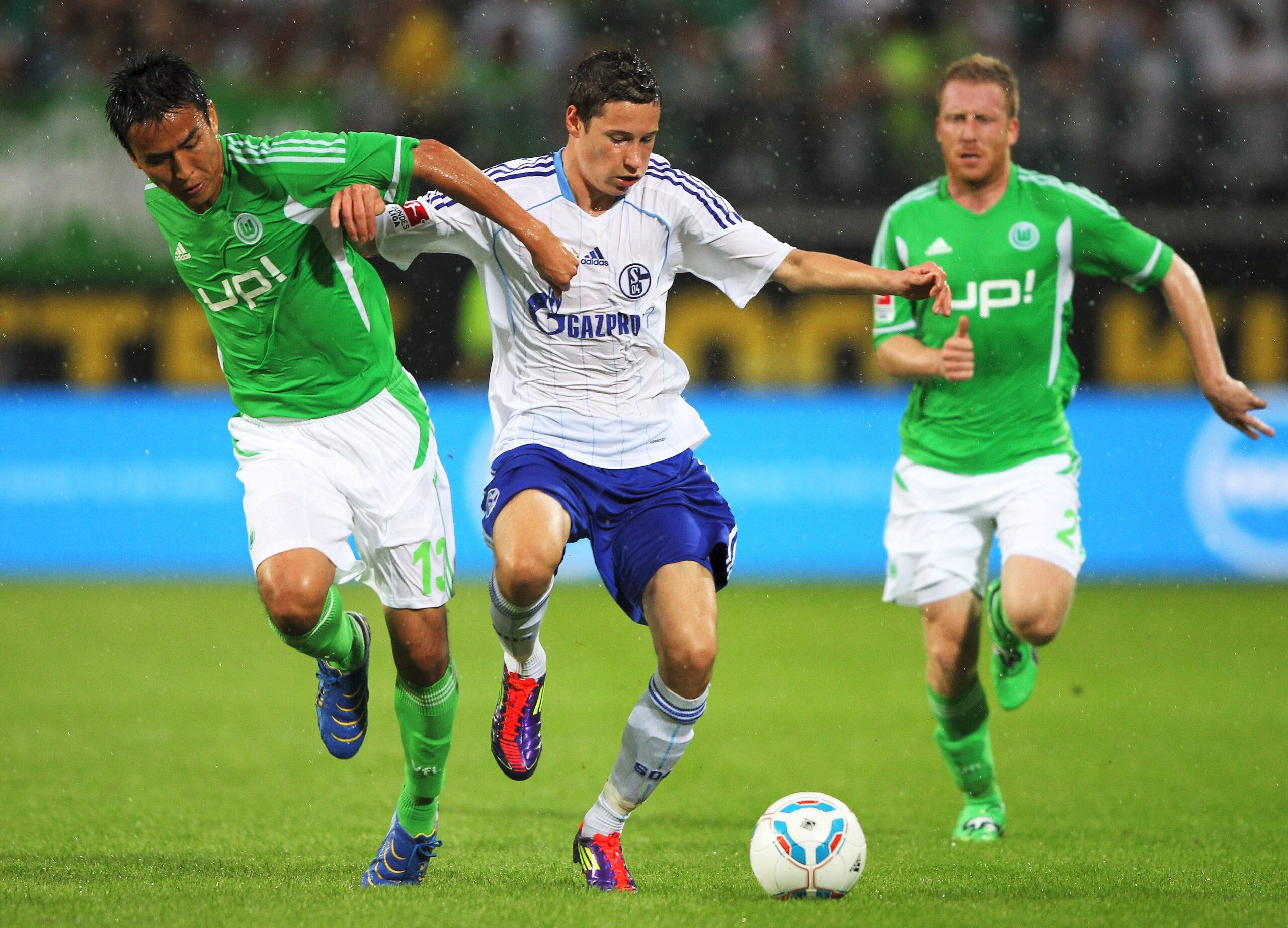 VfL Wolfsburg gegen Schalke 04, Endstand 2:1. Makoto Hasebe (l.) und Patrick Ochs nehmen Julian Draxler in die Zange.