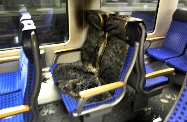 Das Foto der Polizei zeigt verbrannte Sitzbezüge in einem Regionalexpress. 