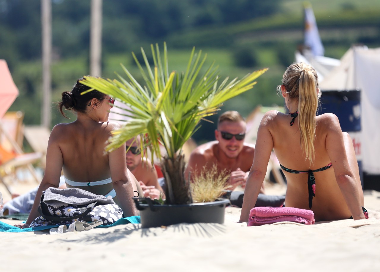 Menschen sonnen sich in einem Freibad. (Symbolbild)