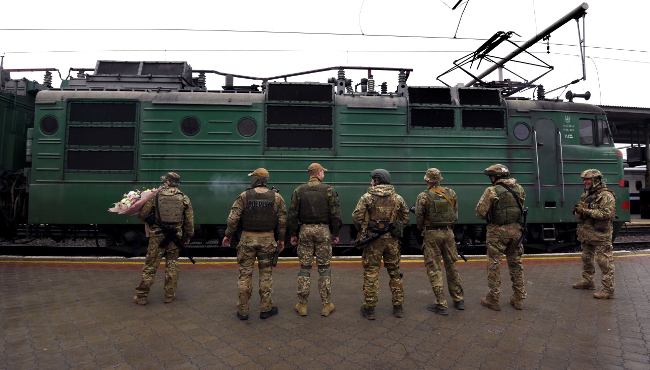29.05.2022, Ukraine, Charkiw: Ukrainische Soldaten warten am Bahnhof auf ihre Frauen. Die Familien waren während der russischen Invasion evakuiert worden.