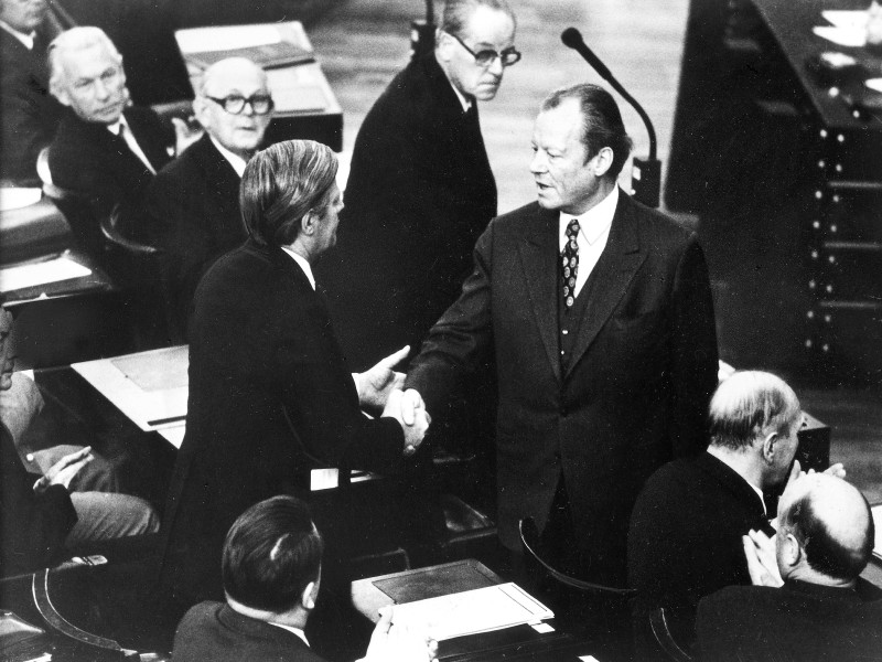 Am 16. Mai 1974 wird Helmut Schmidt (stehend links) mit 267 von 492 Stimmen zum Bundeskanzler gewählt. Einer der ersten Gratulanten ist sein Vorgänger Willy Brandt. In der Mitte steht die SPD-Größe Herbert Wehner.