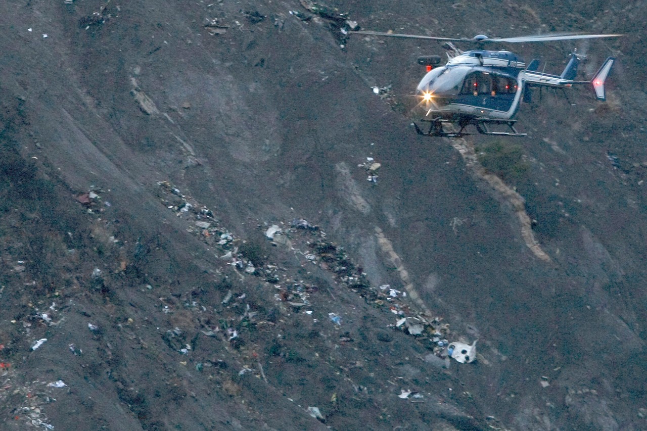 Ein Hubschrauber überfliegt das Trümmerfeld des Germanwings-Absturzes 2015. 