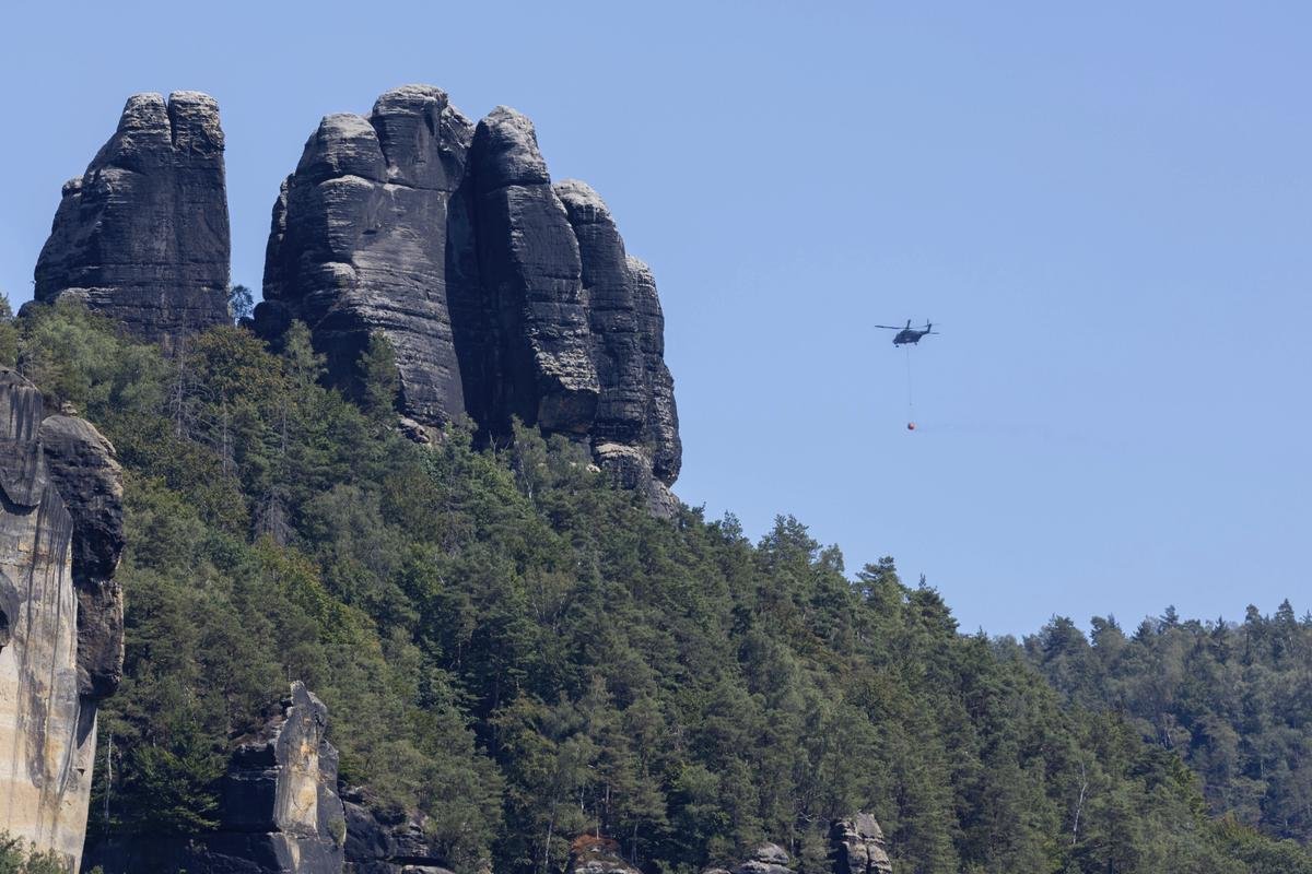 Ein Löschhubschrauber der Bundeswehr ist bei den Waldbränden in der Sächsischen Schweiz im Einsatz. Die Situation im Waldbrandgebiet Nationalpark Sächsische Schweiz ist noch nicht unter Kontrolle. Der Waldbrand im Nationalpark hat den Aufschwung der Tourismuswirtschaft nach der Corona-Pandemie gestoppt.