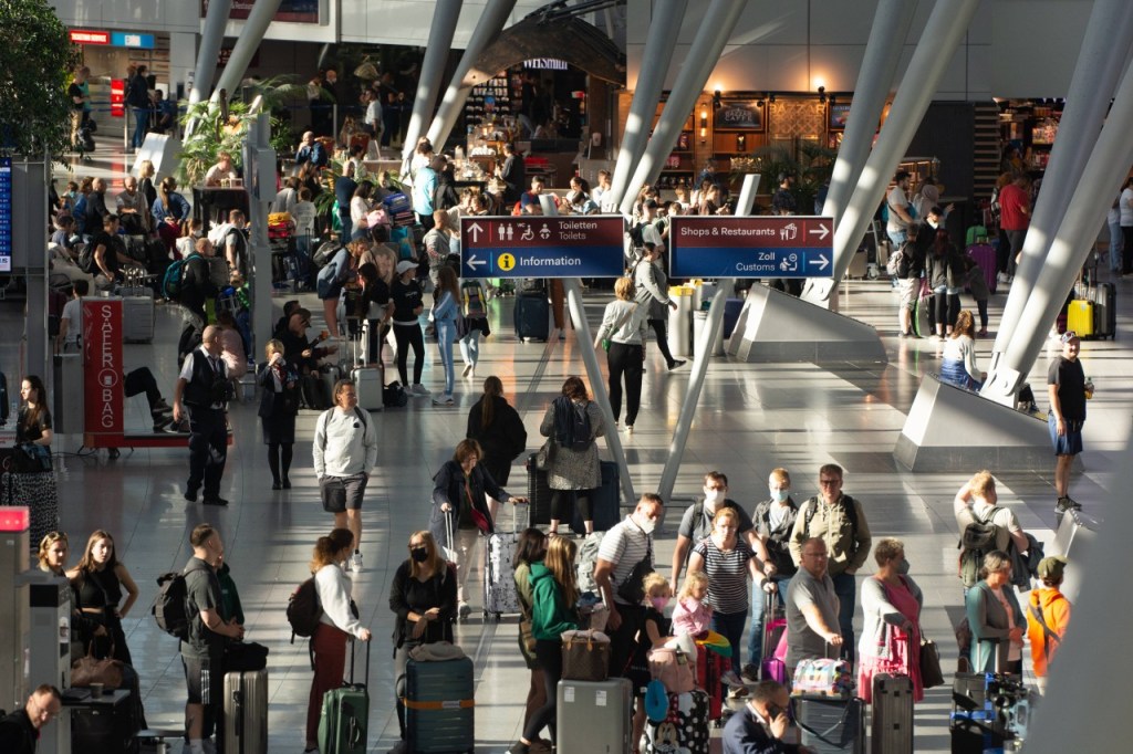 Am Flughafen Düsseldorf drängen sich Reisende dicht an dicht.