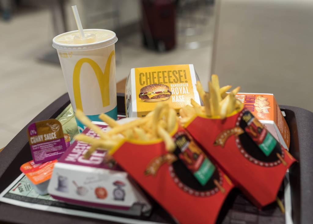 Auf einem McDonald's-Tablette stapeln sich Pommes, Burger und ein Getränk.