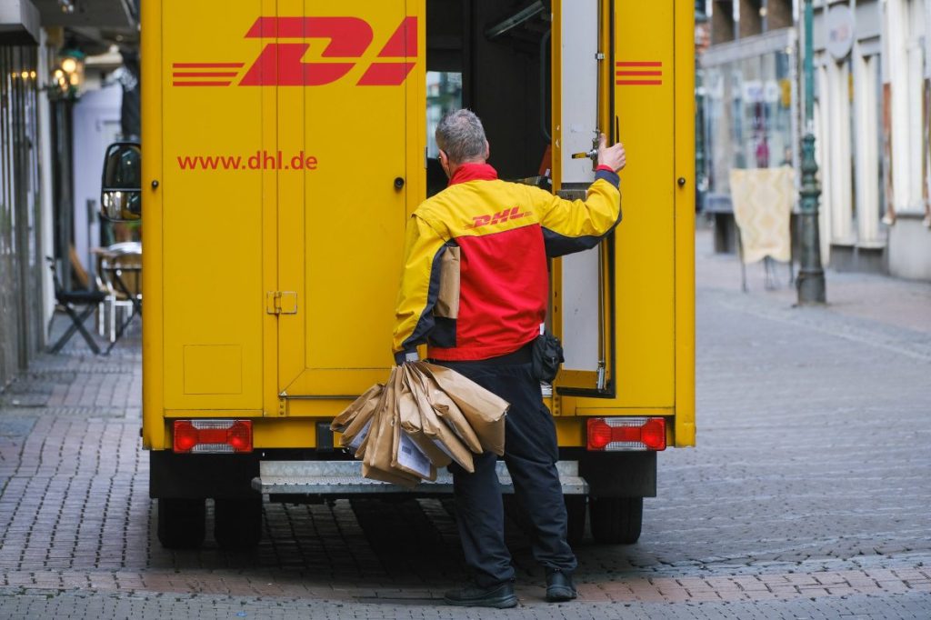 DHL: Paketbote liefert aus.