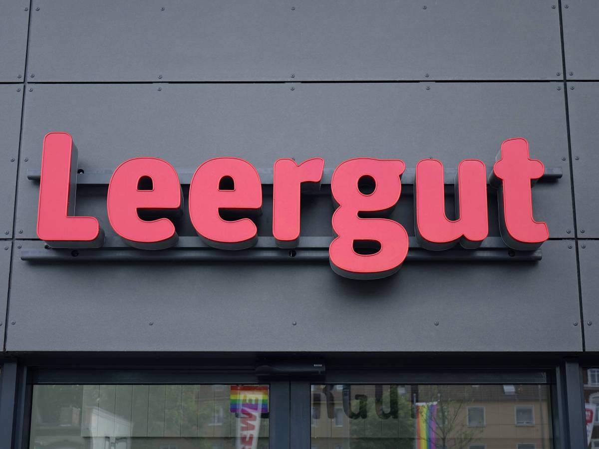 Das Wort "Leergut" in roten Buchstaben auf der grauen Fassade einer Rewe-Filiale.
