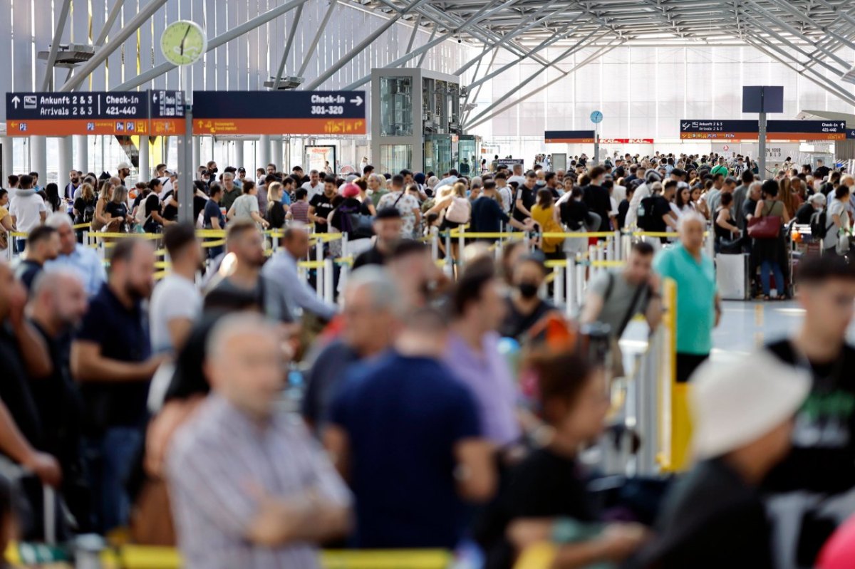 Am Flughafen drängen sich die Reisenden dicht an dicht.