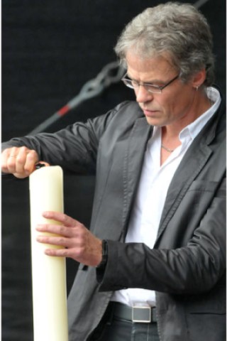 Pfarrer Friedrich Laker zündet bei der Gedenkpause um 18.45 Uhr eine Kerze an. Foto: Vossgraff/WAZ-Fotopool
