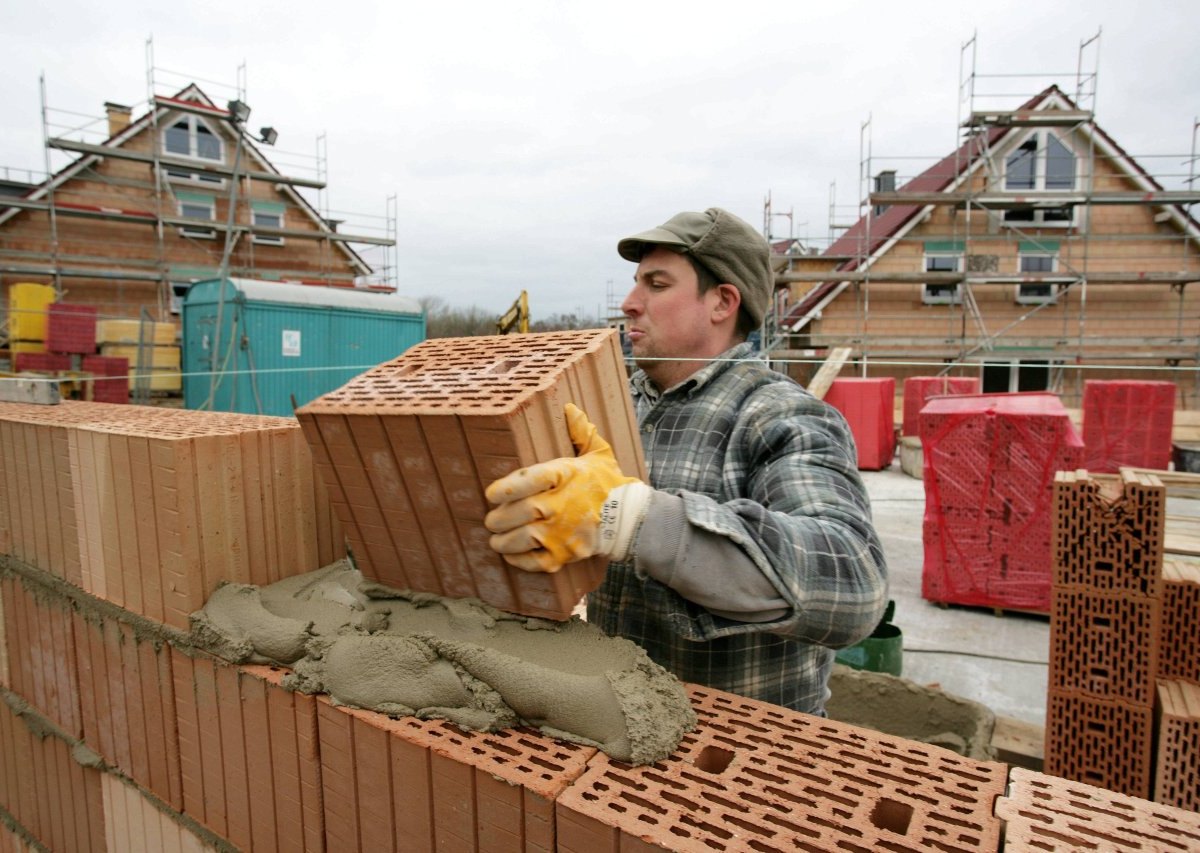 Bauarbeiter mauert eine Außenwand eines.jpg