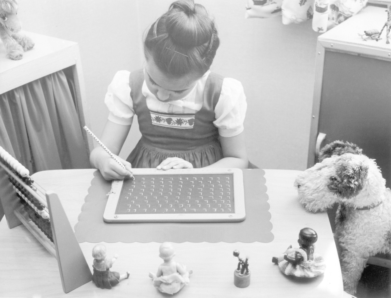 60er Jahre: Eine Schülerin der ersten Klasse macht ihre Hausaufgaben mithilfe einer Schiefertafel. (Foto: dpa)