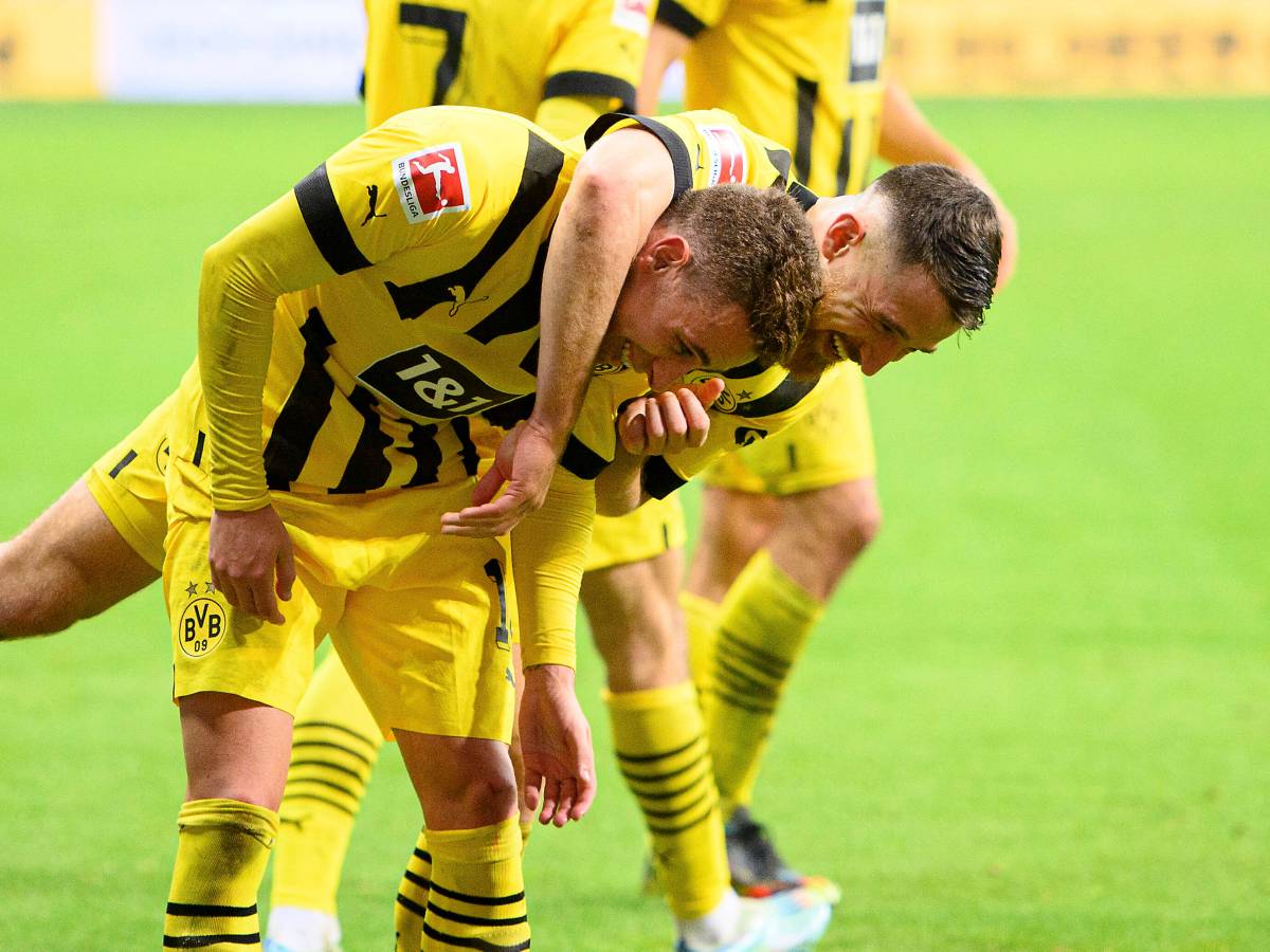Thorgan Hazard wird von seinem Mitspieler Salih Özcan geherzt.