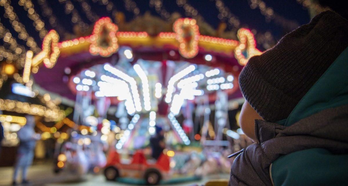 Kind blickt auf das Karussell auf dem Essener Weihnachtsmarkt