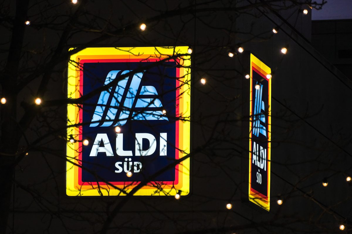 Aldi Süd Logo mit Baumästen und Lichterkette davor