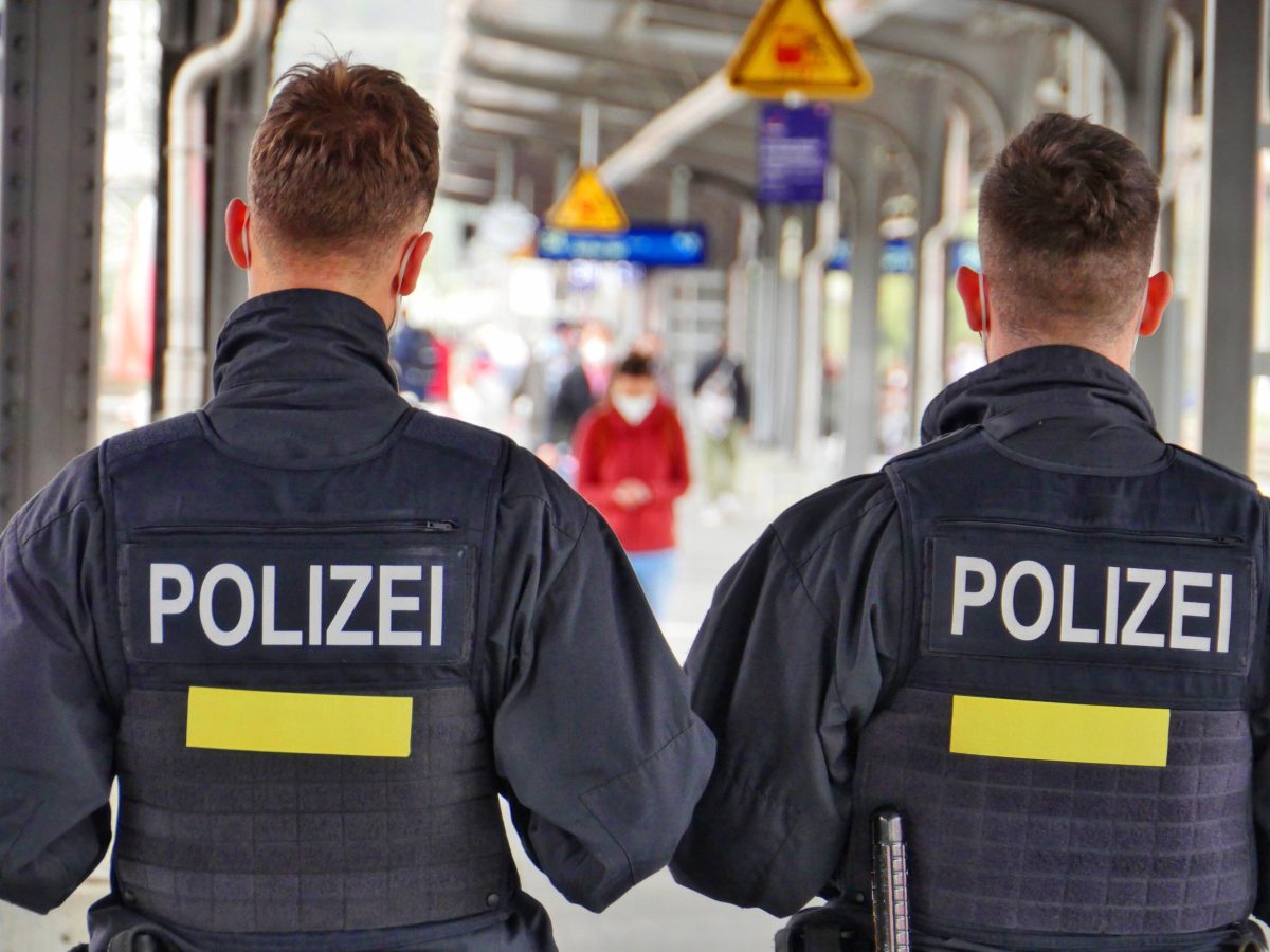 Zwei Polizeibeamte an einem Bahngleis