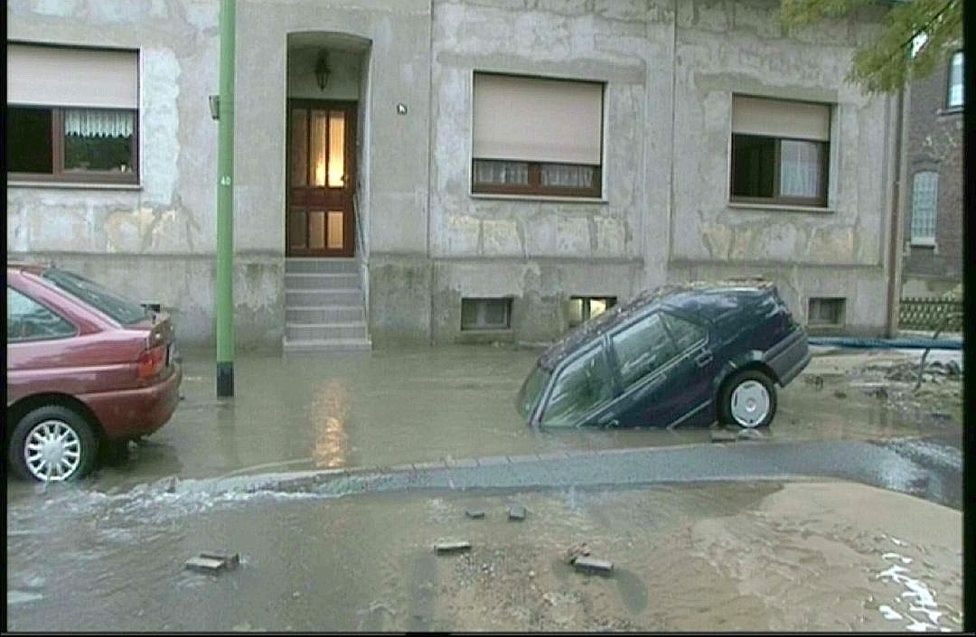 16.Oktober 2010: Ein Auto droht nach einem Wasserrohrbruch in Essen-Dellwig, in dem Loch zu versinken. Die Feuerwehr barg den Wagen schließlich mit einem Kran.