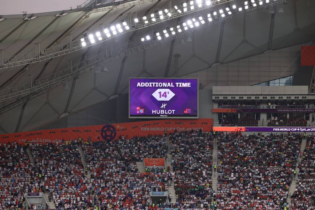 Eine Leinwand bei der WM 2022 zeigt 14 Minuten Nachspielzeit an.