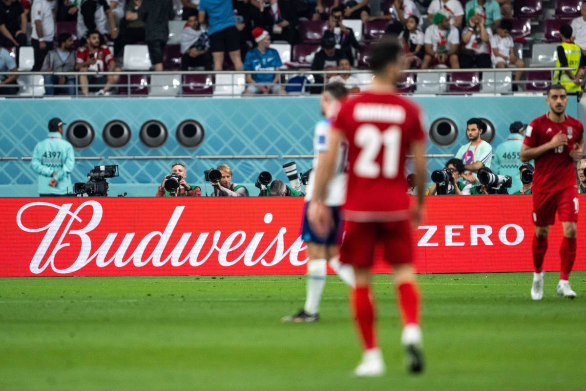 Spieler laufen in Katar vor einer Budweiser-Werbebande über den Platz.