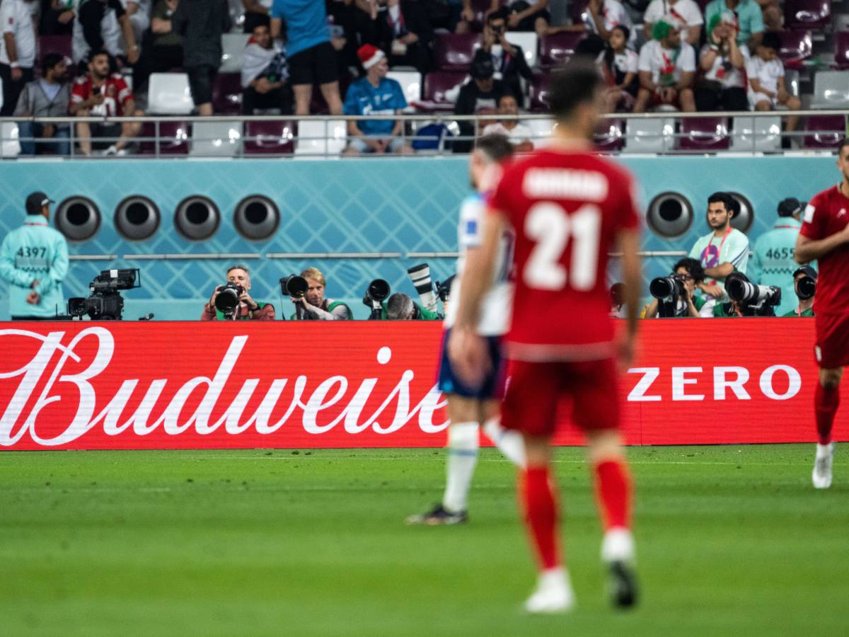 Spieler laufen in Katar vor einer Budweiser-Werbebande über den Platz.