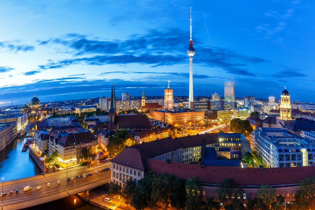 Blick auf die Skyline von Berlin mit dem Fernsehturm, und dem Rathaus bei Nacht.