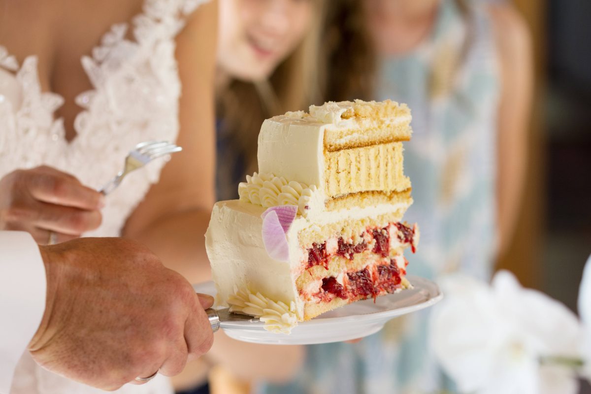 Hochzeit Braut und Bräutigam schneiden Torte an