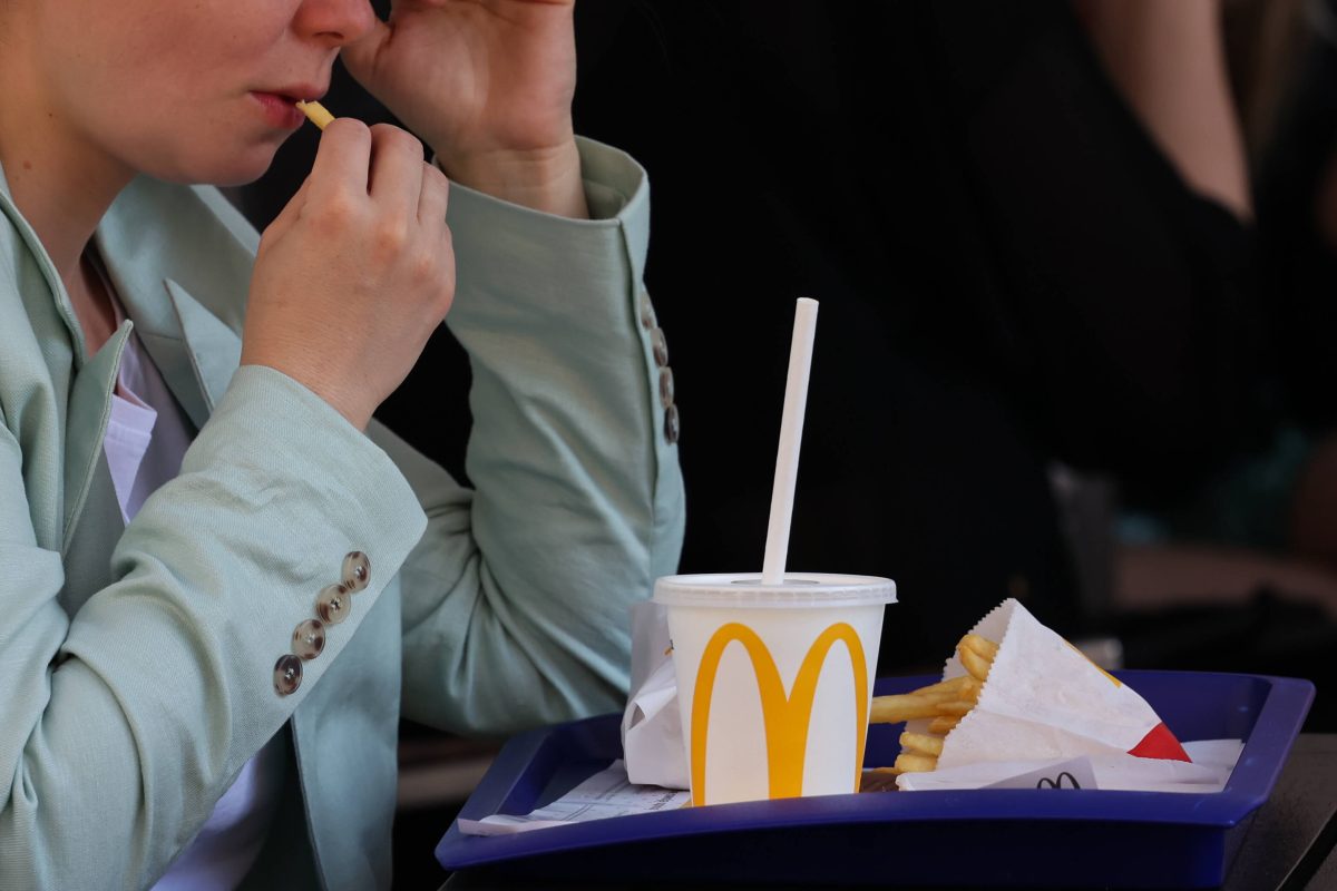 McDonald's-Kundin mit Pommes und Getränk auf dem Tablett