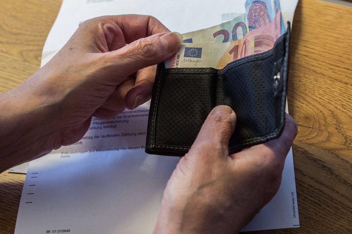 Ältere Frau fasst ins Portemonnaie Euroscheine Rechnung