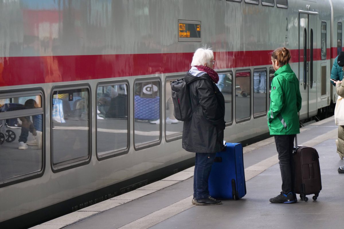 Deutsche Bahn IC-Zug und Fahrgäste warten davor