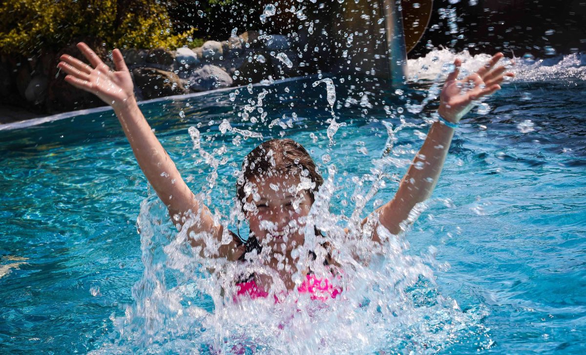 Mädchen spritz mit Wasser in Schwimmbecken