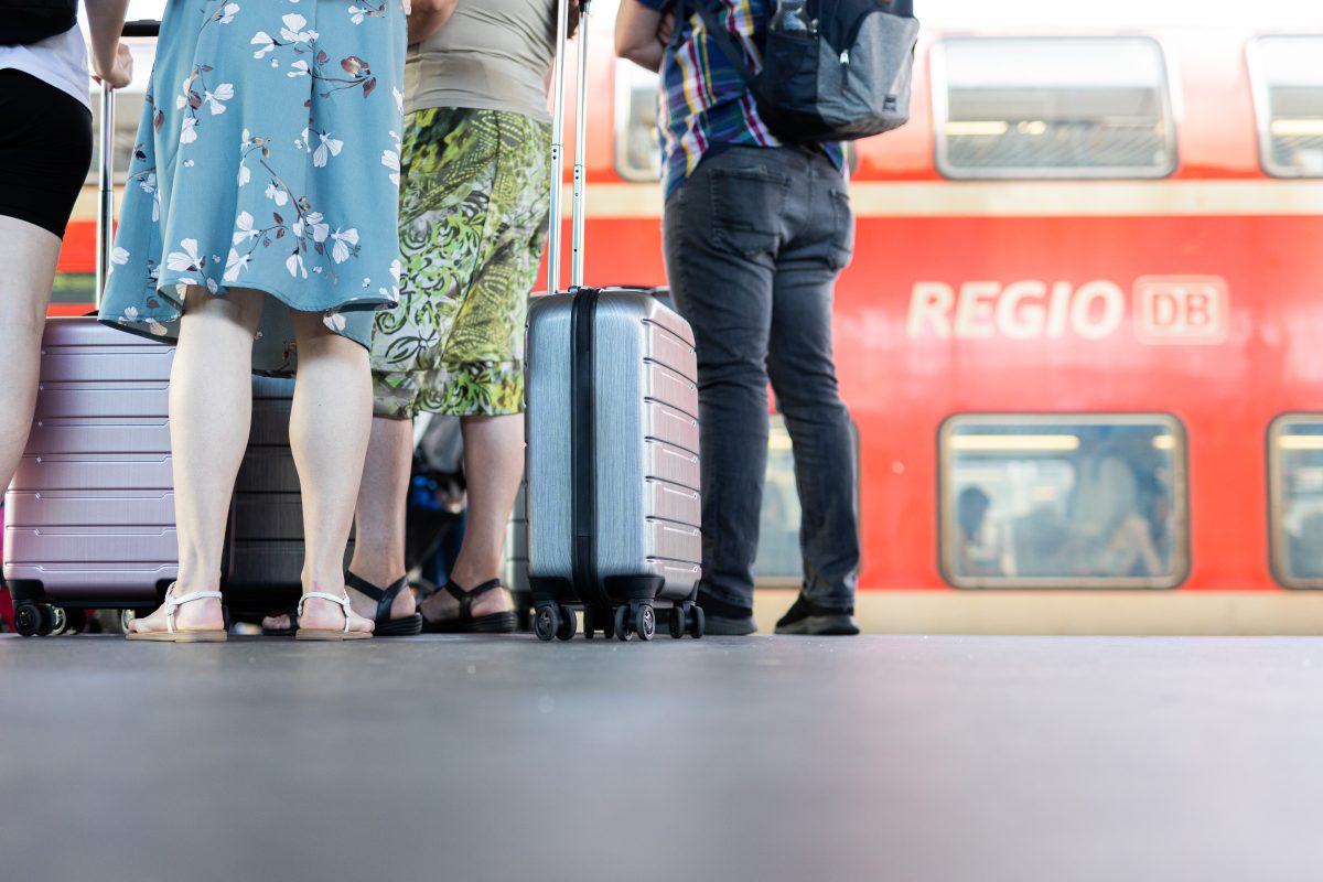 FahrgÃ¤ste warten mit ihrem GepÃ¤ck vor einem Regionalexpress der Deutschen Bahn in NRw