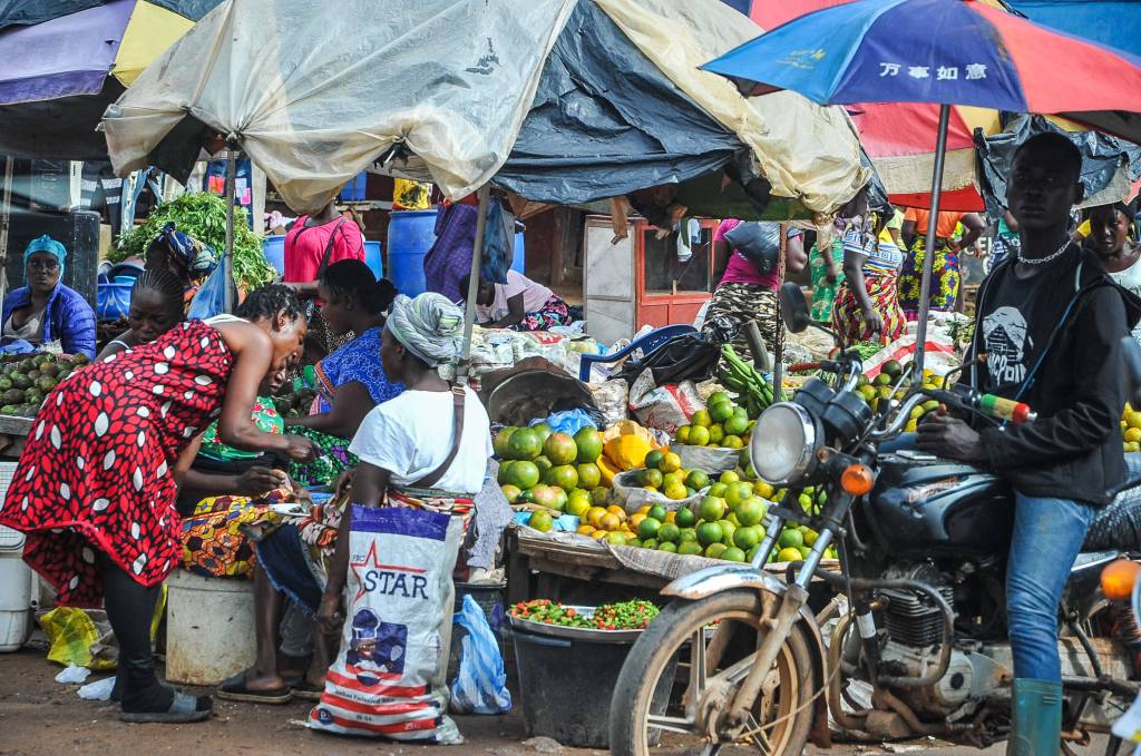Menschen stehen vor einem Gemüsestand auf einem Markt in Monrovia.