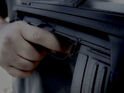 Mann hält Finger am Abzug seines Gewehres