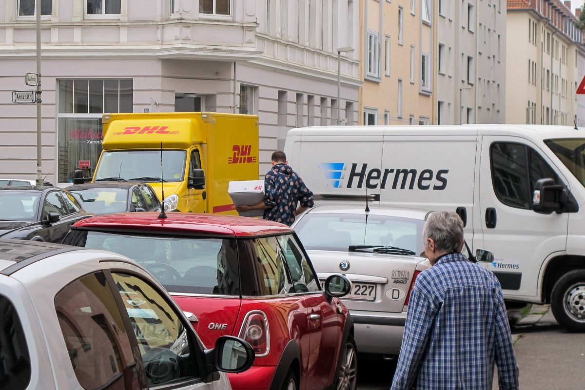 DHL- und Hermes-Paketwagen im Straßenverkehr