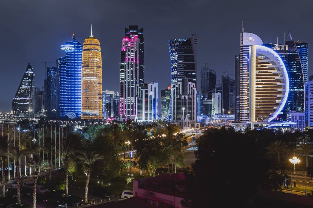 Die Skyline von Doha (Katar) ist bei Dunkelheit bunt illuminiert.