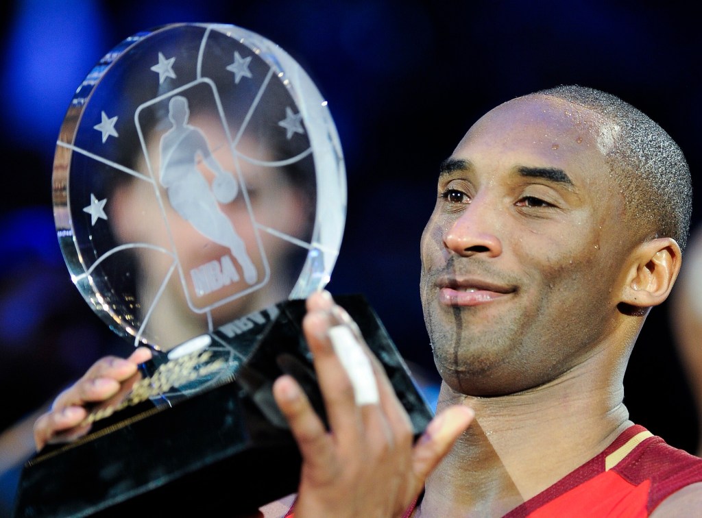 Kobe Bryant posiert mit einem gläsernen Pokal.