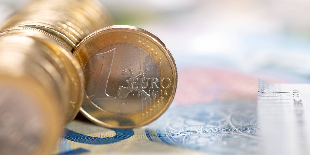Eine 1-Euro-MÃ¼nze steht senkrecht in einer Reihe von MÃ¼nzen.