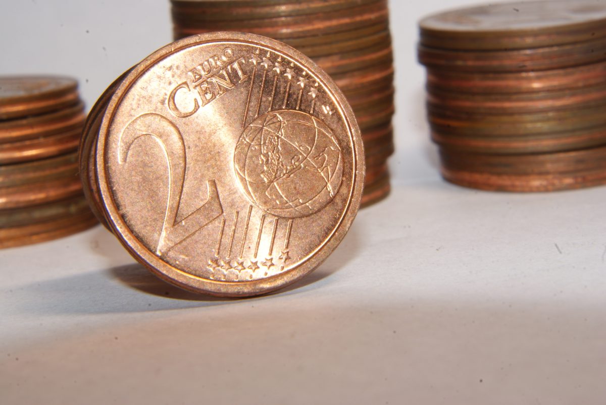 Nahaufnahme einer 2-Cent-Münze vor einem Stapel mit Cent-Münzen.