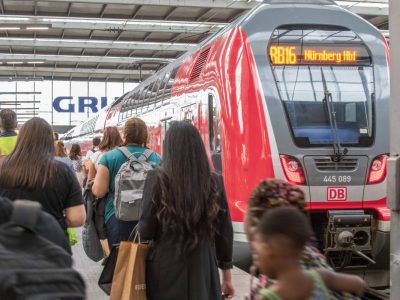 Fahrgäste vor einem Zug der Deutschen Bahn